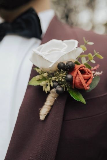 groom boutonniere with wood flowers - white rose and red rose and berries 