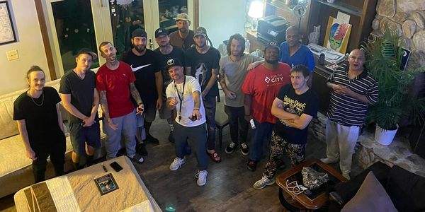 Group of men posing indoors in a casual setting.