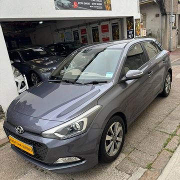Gray Hyundai hatchback parked near a garage entrance.