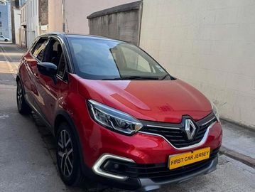 Red Renault car parked in an alleyway with a bright yellow license plate.