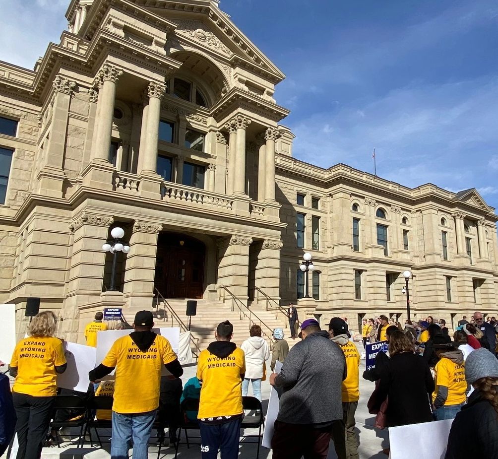 Protesters gather outside a historic government building for Medicaid expansion.