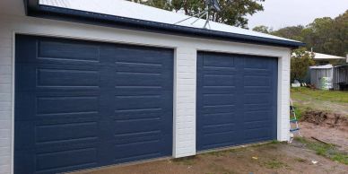 A double garage with dark blue doors.