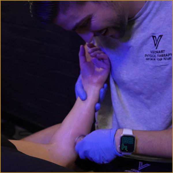 Physical therapist applying cupping therapy on a patient's forearm.