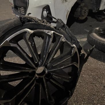 Severely damaged car wheel and tire.