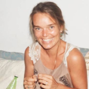 Mujer sonriente con camiseta sin mangas posando para la foto.