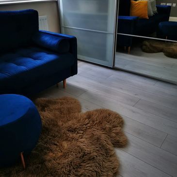 Blue velvet sofa and fuzzy brown rug
