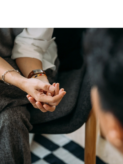 Therapist sits facing her client in a welcoming posture.