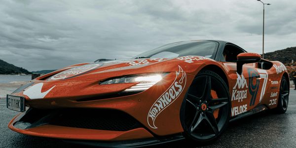 Sleek, fiery orange supercar with aerodynamic curves and roaring horsepower. 