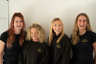4 women laughing in EH Cleaning Ltd uniform. Commercial cleaning. Certified and Trained cleaners.