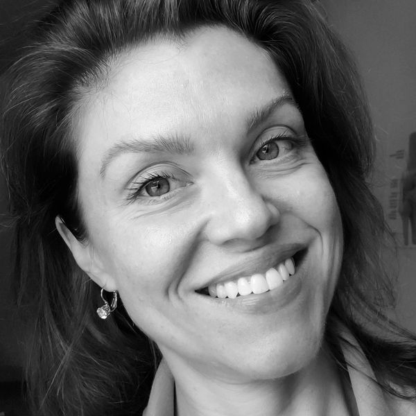 Close-up black and white portrait of a smiling woman with earrings.