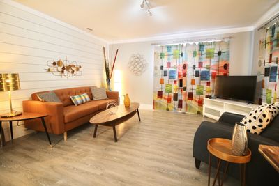 Bright retro living room with colorful curtains and modern furniture.