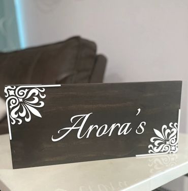 An artistic wooden sign with acrylic family name. Indian name plate with intricate design in acrylic