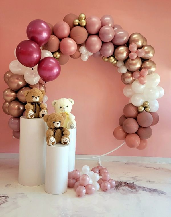 Teddy bears and balloons arranged in a pastel-themed decorative display.