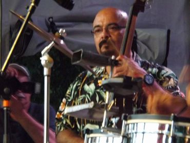 A musician playing percussion instruments during a live performance.