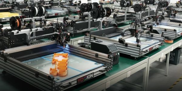 3D printers arranged on tables printing objects.