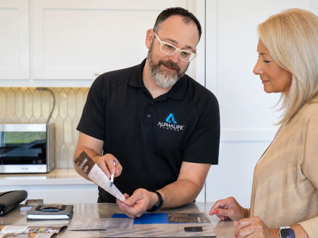 Man explaining a brochure to a woman at a counter.