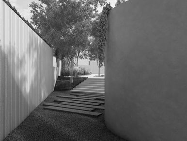 Black and white photo of a modern outdoor walkway with trees.