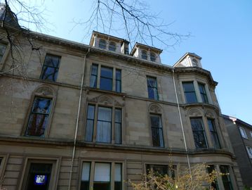 Old stone building with multiple windows and dormers.