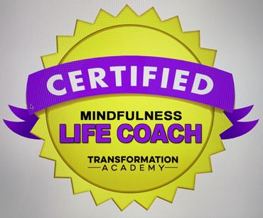 Yellow badge certifying a mindfulness life coach from Transformation Academy.