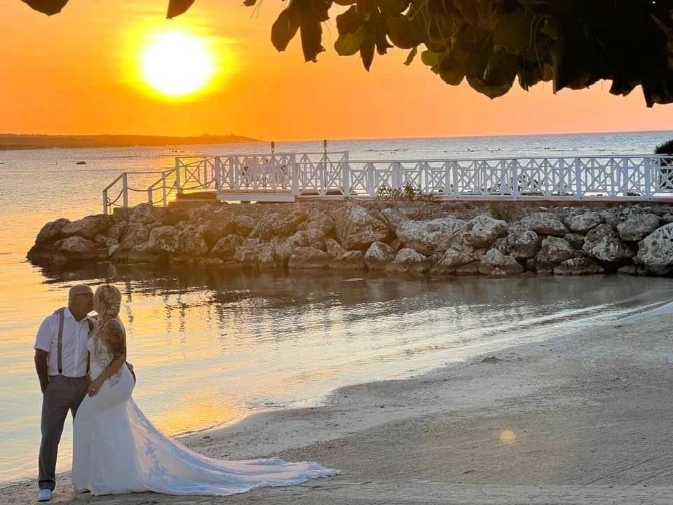 Couple kissing on a beach at sunset.