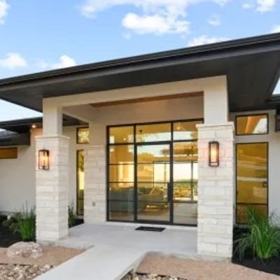 Modern luxury custom home entryway with premium stone and wood finishes, built by Volterra Custom Ho