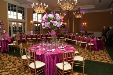 Elegant banquet hall with pink-themed tables and floral centerpieces.