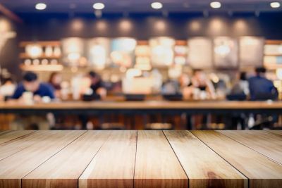 Empty wooden table with blurred cafe background.