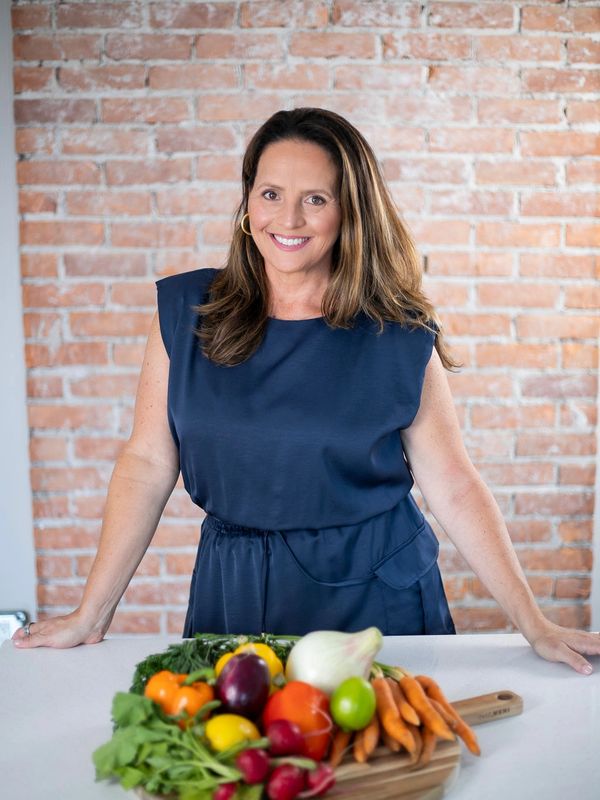 Christa standing behind a platter of fruits and vegetables