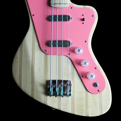 Electric bass guitar with natural wood and pink pickguard.