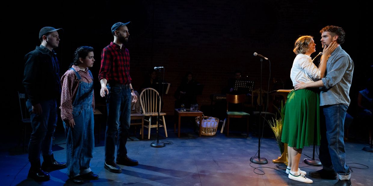 Actors performing a dramatic scene with contrasting emotions on stage.