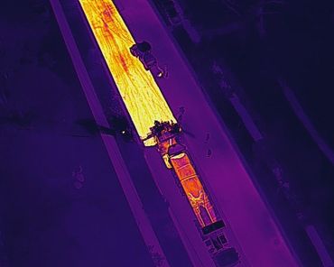 Thermal image of a truck on a road at night.