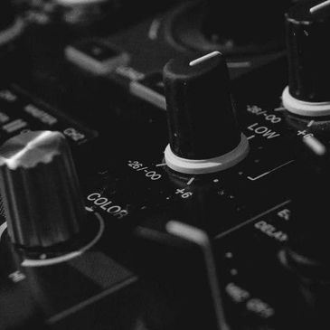 Close-up of audio mixer knobs in monochrome.