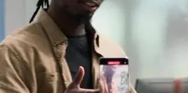 A person showing a smartphone with an image on its screen.