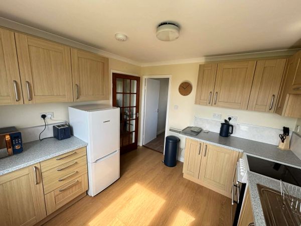 Bright kitchen with wooden cabinets and modern appliances.