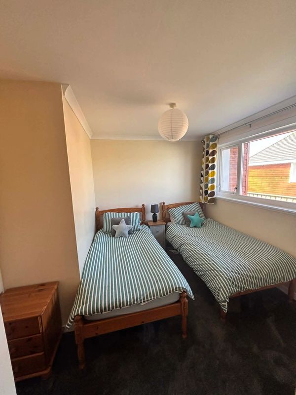 A cozy bedroom with two single beds and striped bedding.
