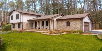 Spacious two-story house with brick and siding exterior and a large green lawn.