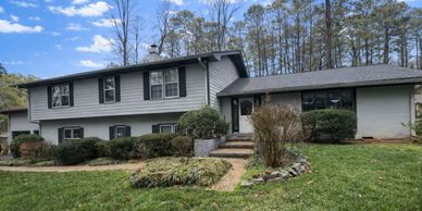 Two-story suburban house with gray siding and a well-maintained front yard.