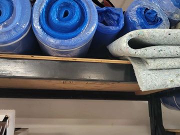 rolls of blue carpet underlay on a shelf