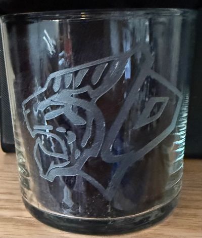 Glass with an etched design of a roaring panther head.