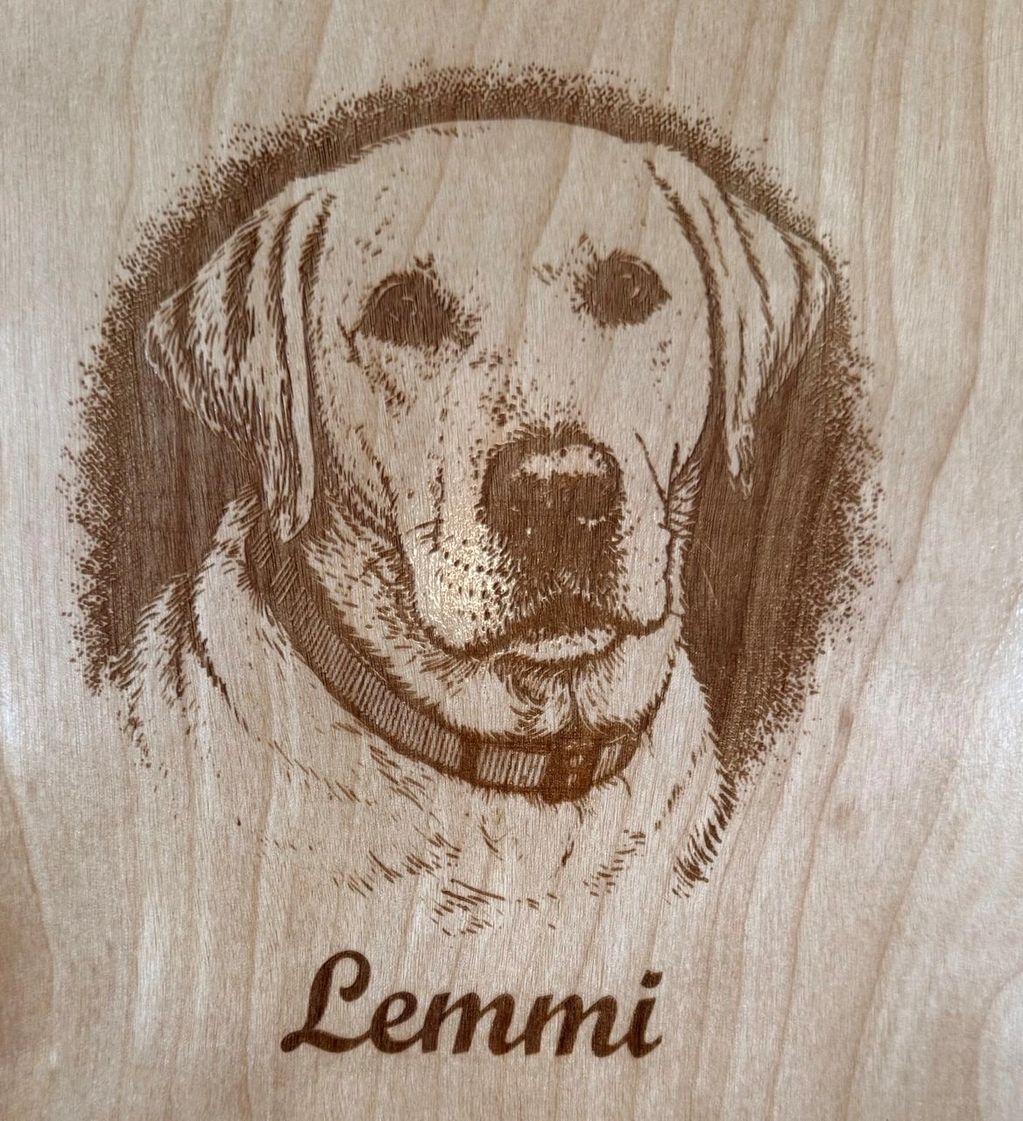Engraved wooden portrait of a dog named Lemmi.