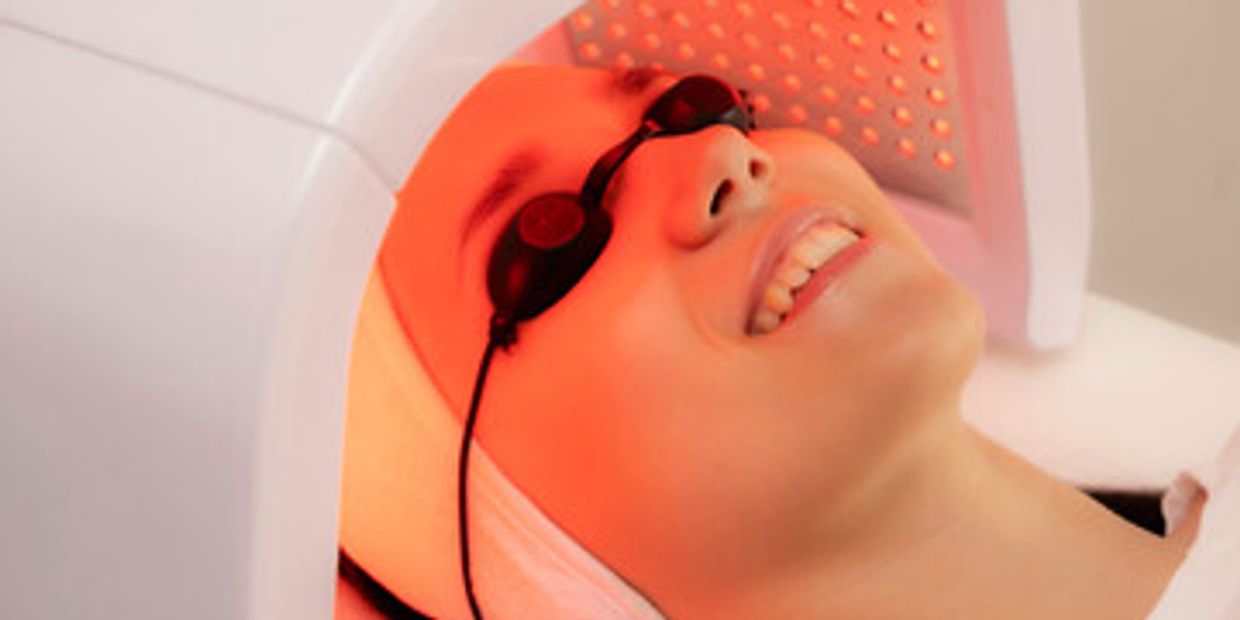 Woman receiving red light face therapy 
