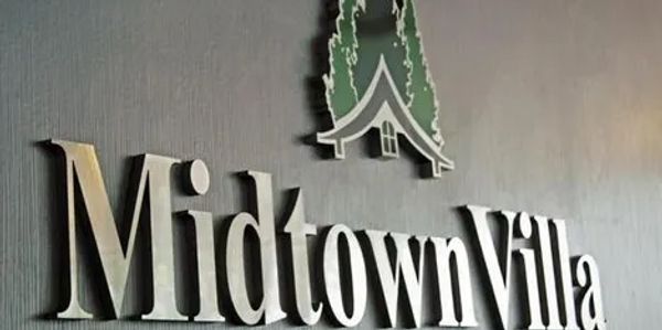 3D wall sign reading 'Midtown Villa' with a cabin and trees graphic.