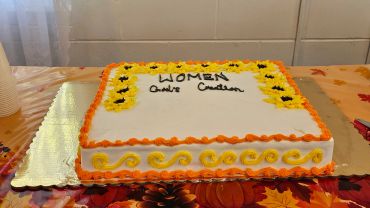 Square cake decorated with orange and yellow icing.