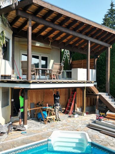 Workers constructing a covered patio extension.