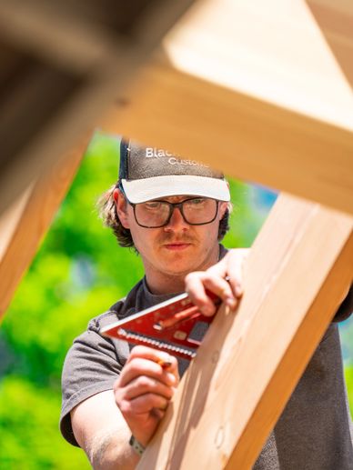 Man measuring wood with a carpenter's square.