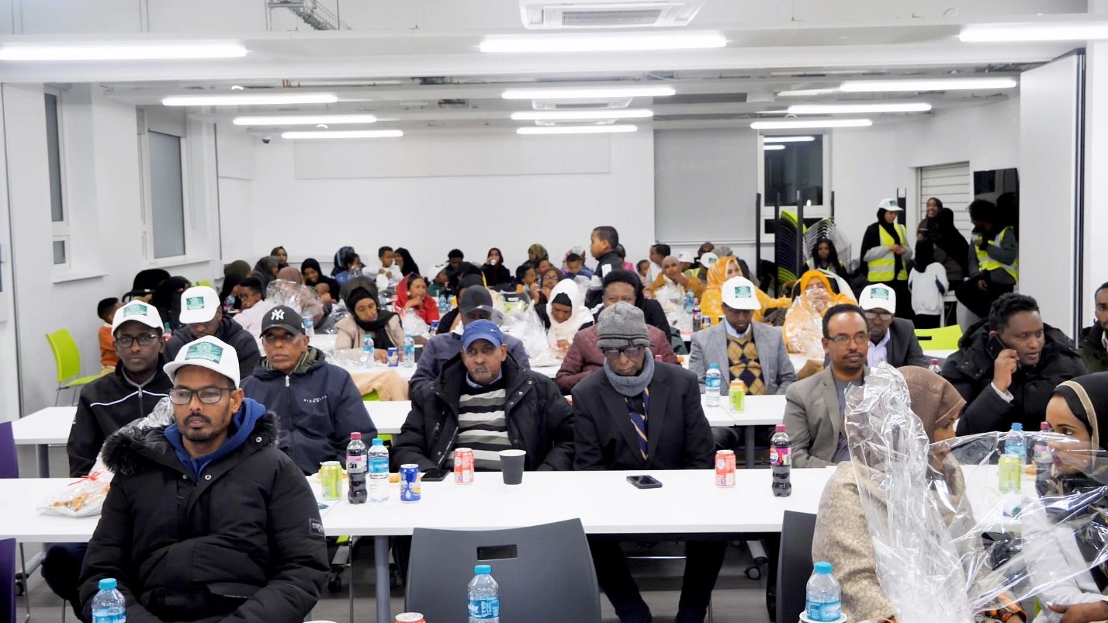 Community members gathered in a spacious, well-lit room for a meeting or event.