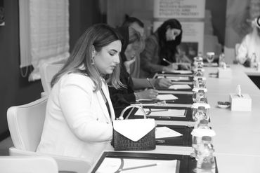 Women writing at a conference table.