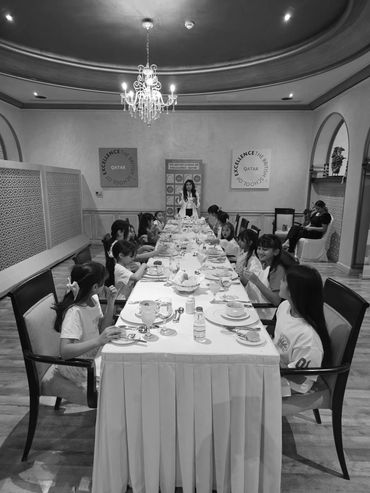 Group of children sitting at a long dining table.