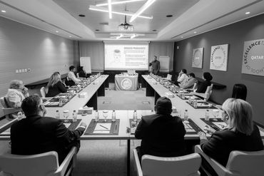 People attending a formal business presentation in a conference room.