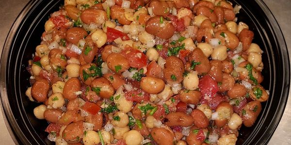 A colorful bean salad with herbs and diced vegetables.